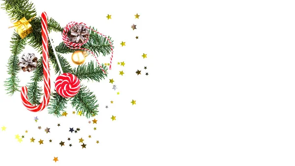 Decoraciones navideñas y rama de árbol sobre fondo blanco. Dulces rayados, manzana roja, cono, hilo rayado y confeti. Acostado. Año Nuevo y estado de ánimo de Navidad — Foto de Stock