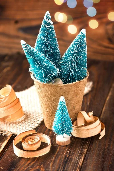 Pequeños árboles de Navidad artificiales en musgo de turba biodegradable y virutas de madera. Año Nuevo y Navidad respetuosos con el medio ambiente —  Fotos de Stock