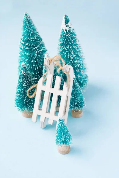 Composição de inverno de Natal. Sledge branco de madeira e abetos em azul — Fotografia de Stock