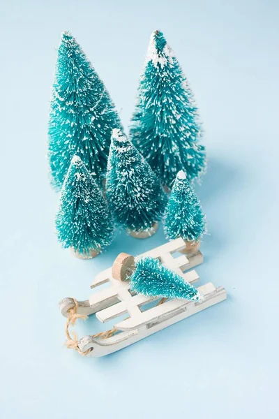 Composição de inverno de Natal. Sledge branco de madeira e abetos em azul — Fotografia de Stock