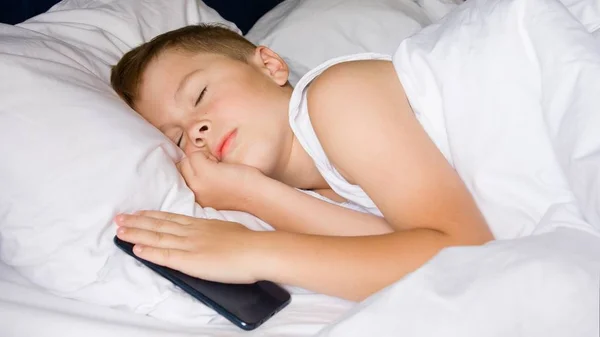 Dormindo adolescente menino segurando seu smartphone — Fotografia de Stock