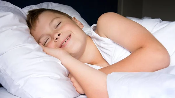 Anak muda berbaring di kamar tidur dan tersenyum — Stok Foto