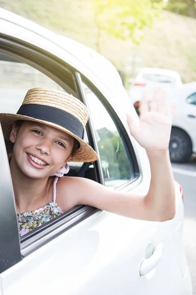 Smiling happy girl in straw hat in car window. Travel with kids. Travel by car — Stock Photo, Image