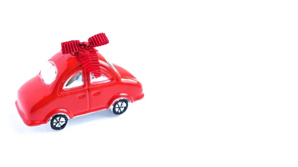 Red toy car with bow on white background. Cope space. Present for woman — Stock Photo, Image