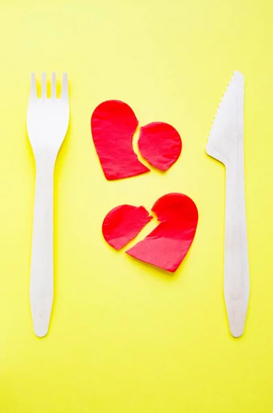 Bamboo biodegradable fork made of natural eco recycle reusable material and two broken paper hearts on yellow. — Stock Photo, Image