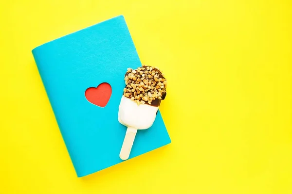 Cuaderno azul con corazón rojo y paleta en amarillo. San Valentín . —  Fotos de Stock