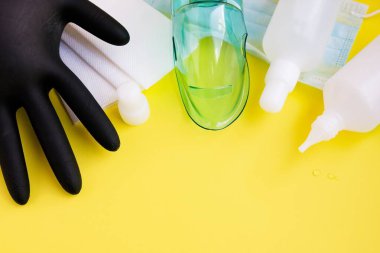 Siyah tıbbi eldiven, koruyucu maske, beyaz şişelerde anti bakteriyel dezenfektanlar, kağıt mendiller. Pandemik koronavirüs sırasında kişisel hijyen kavramı. Boşluğu kopyala