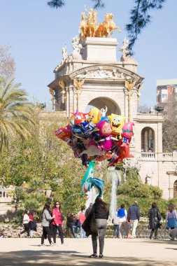 Barcelona, İspanya - 23 Şubat 2020: Kız tatilde Parc de la Ciutadella 'da coloful balonları satıyor. Barselona 'da en çok ziyaret edilen turistik yerlerden biri.