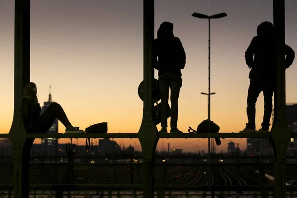 Mladí lidé na mostě Hackerbruecke v Mnichově, Německo, sledování západu slunce — Stock fotografie