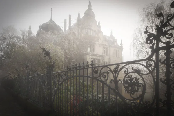 Villa velha com cerca de ferro no nevoeiro da manhã — Fotografia de Stock
