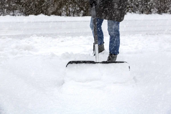 Жінка скидає сніг на тротуарі — стокове фото