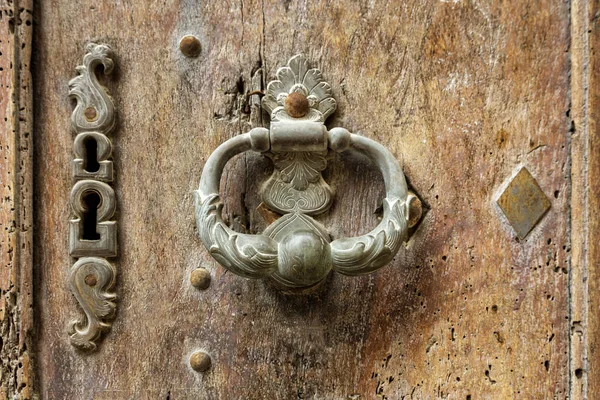 Old metal door handle and knocker on wooden door — Stock Photo, Image