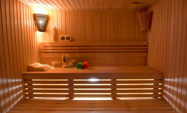 Sauna. Banyo Aksesuarları: kova, kaşık oyma, şapka, haddelenmiş rulo havlu ve kokulu mumlar bir vazo.