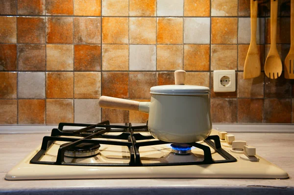 Nueva cacerola con mango de madera en la estufa . — Foto de Stock