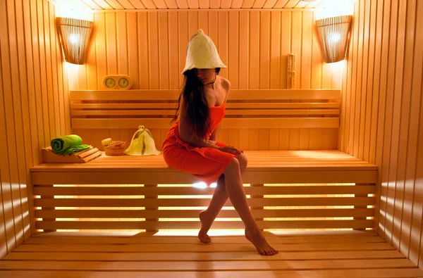 Hermosa chica en el sombrero para la sauna y toalla al vapor en el — Foto de Stock