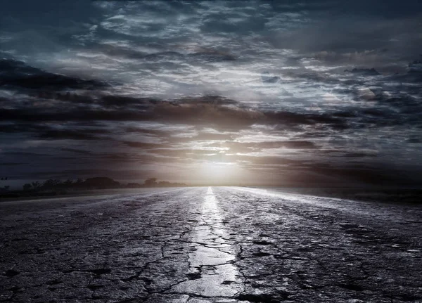 Ночная дорога на фоне кучевых облаков — стоковое фото