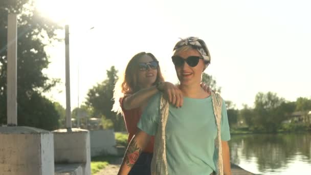 Due amiche a cavalluccio in vacanza ridendo e passeggiando nel Parco — Video Stock