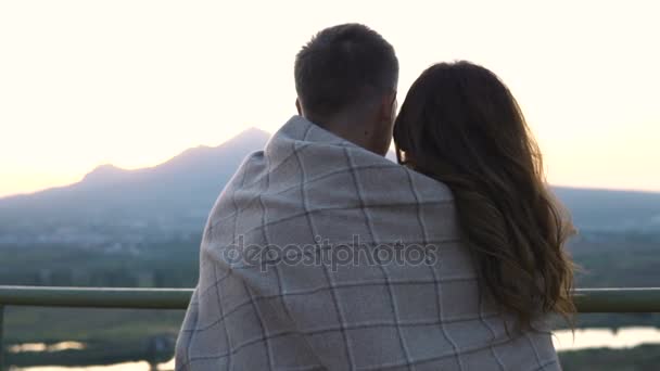 Молода пара закохалася, спостерігаючи за заходом сонця на спостережній вежі — стокове відео