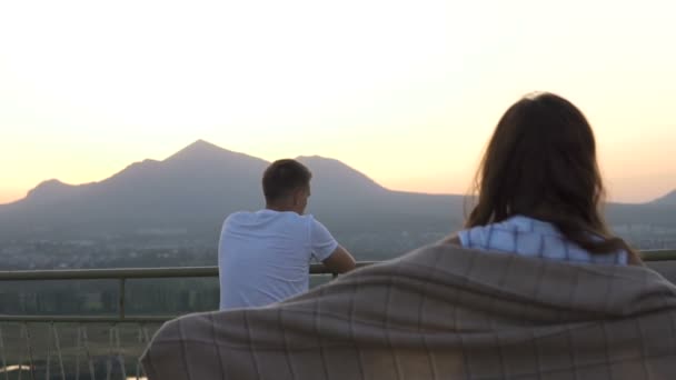 Молодая пара влюблена и смотрит на закат на смотровой башне — стоковое видео