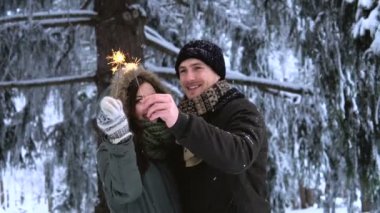 Winter Park. Sevgi dolu genç öpüşme, Çift havai fişekleri holding ve kamera için poz