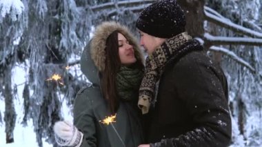 Winter Park. Sevgi dolu genç öpüşme, Çift havai fişekleri holding ve kamera için poz
