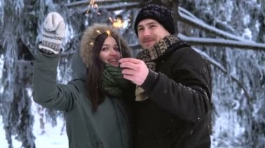 Winter Park. Sevgi dolu genç öpüşme, Çift havai fişekleri holding ve kamera için poz