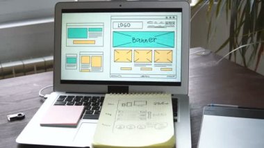 Web geliştirici gelecekteki sitenin bir kroki yapmak masada oturuyor. Uzaktan ev ofisindeki çalışma.