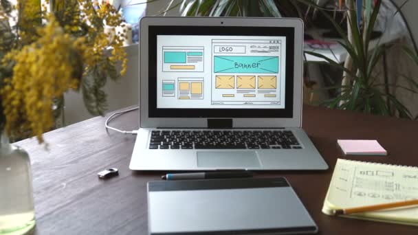 网页开发商坐在桌子上做一个草图的未来网站。从家庭办公室远程工作. — 图库视频影像