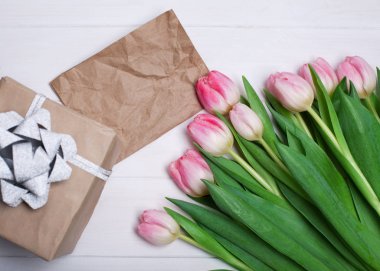 Hediye ve kopya bir alanı yazmak için beyaz bir ahşap zemin üzerine Pembe Laleler