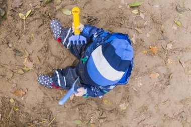 sonbaharda kumda oynayan bebek