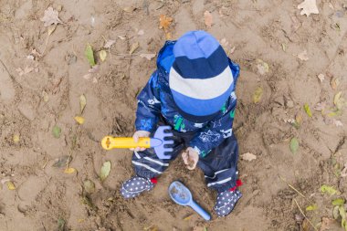 sonbaharda kumda oynayan bebek