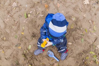 sonbaharda kumda oynayan bebek