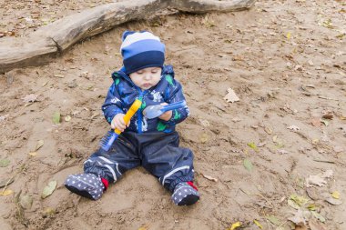 sonbaharda kumda oynayan bebek