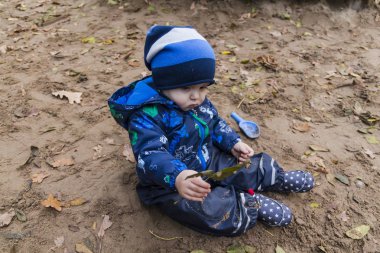 sonbaharda kumda oynayan bebek