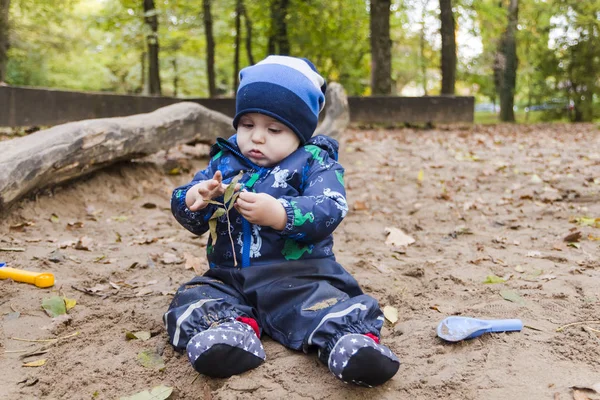 Bebê brincando na areia no outono — Fotografia de Stock