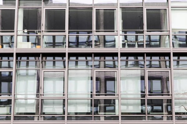 Edificio de fachada con ventanas a la luz del día con reflejos —  Fotos de Stock