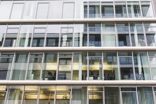 Edificio de fachada con ventanas a la luz del día con reflejos —  Fotos de Stock