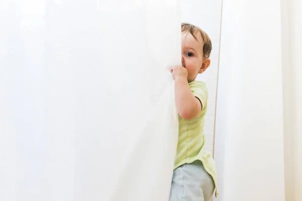 白いカーテンで遊ぶ赤ちゃん — ストック写真