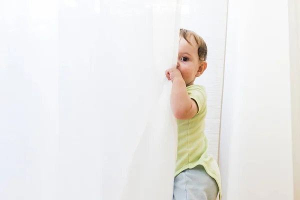 Beyaz perdeler oynayan bebek