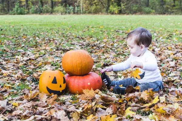 Dziecko bawi się dynie na halloween — Zdjęcie stockowe