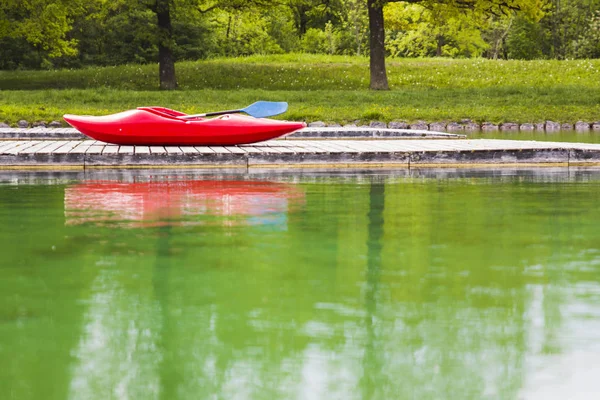 Ein rotes Kajak auf einem Holzsteg in einem See — Stockfoto