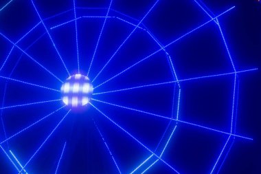 Gece aydınlatılmış bir dönme dolap.