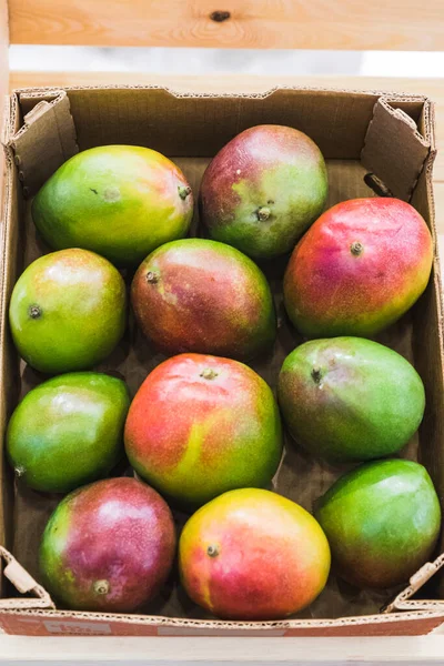 Karton nakliye kutularında yeşil bir mango.