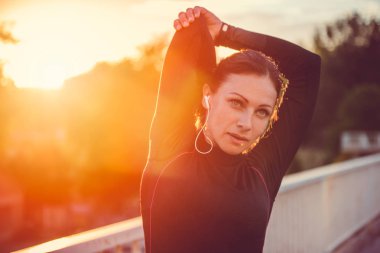 kadının günbatımında germe yapması