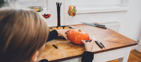 Menina criando Jack-O-Lanterna em casa — Fotografia de Stock