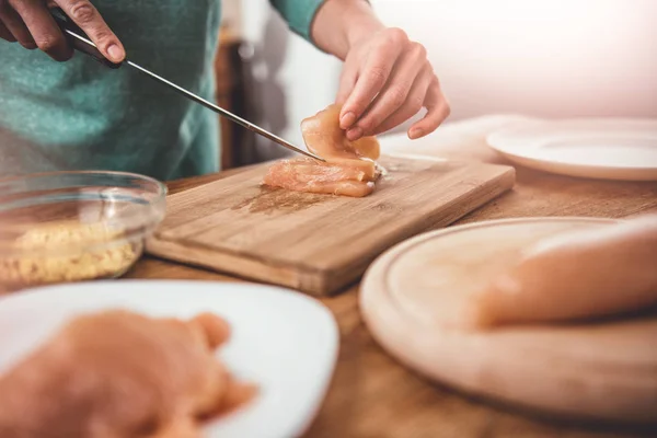 Woman cutting chicken