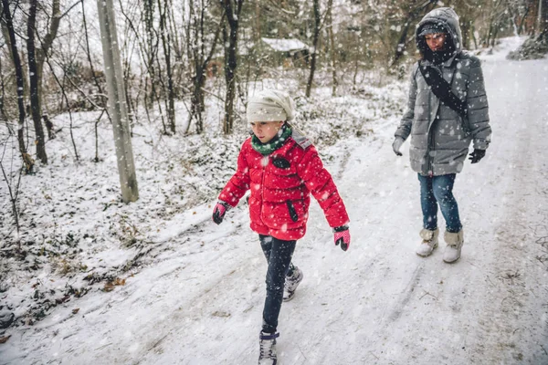 Anne ile kızı karlı ormandaki