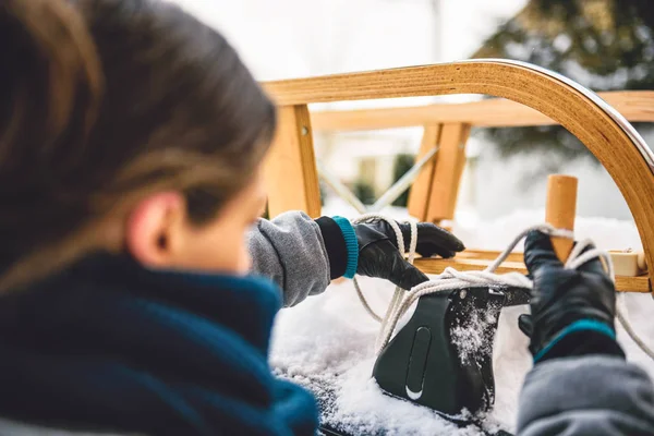 Woman putting sled in car roof — Stock Photo, Image