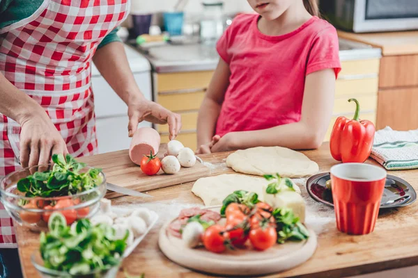Anne ve kızı pizza hazırlıyor. 