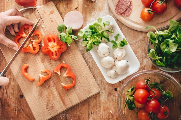 Frau schneidet Paprika an Bord — Stockfoto